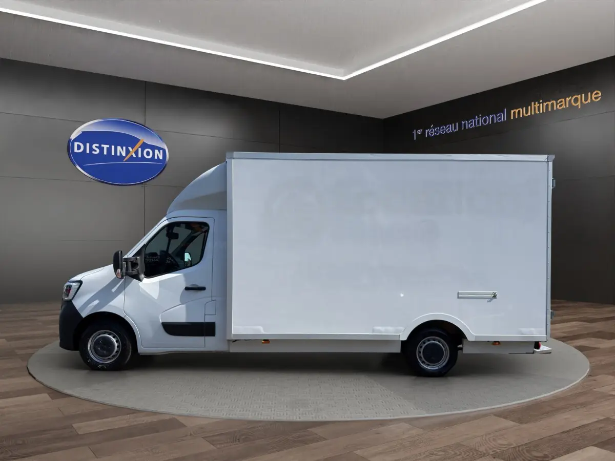 Vue de profil côté gauche d’un utilitaire Renault Master blanc avec caisse fermée, présenté en intérieur showroom.