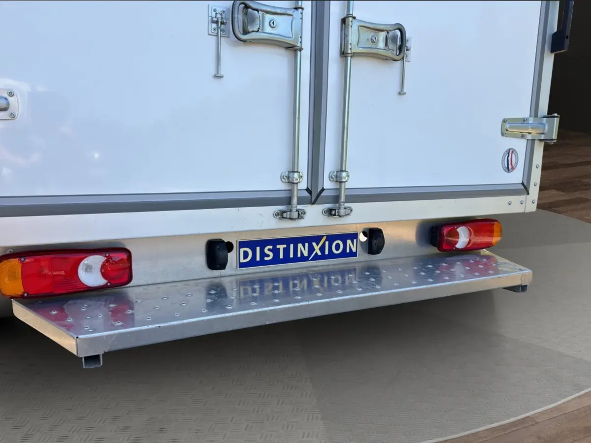 Vue rapprochée arrière du Renault Master blanc, mettant en valeur la porte de chargement et les feux arrière rouges.