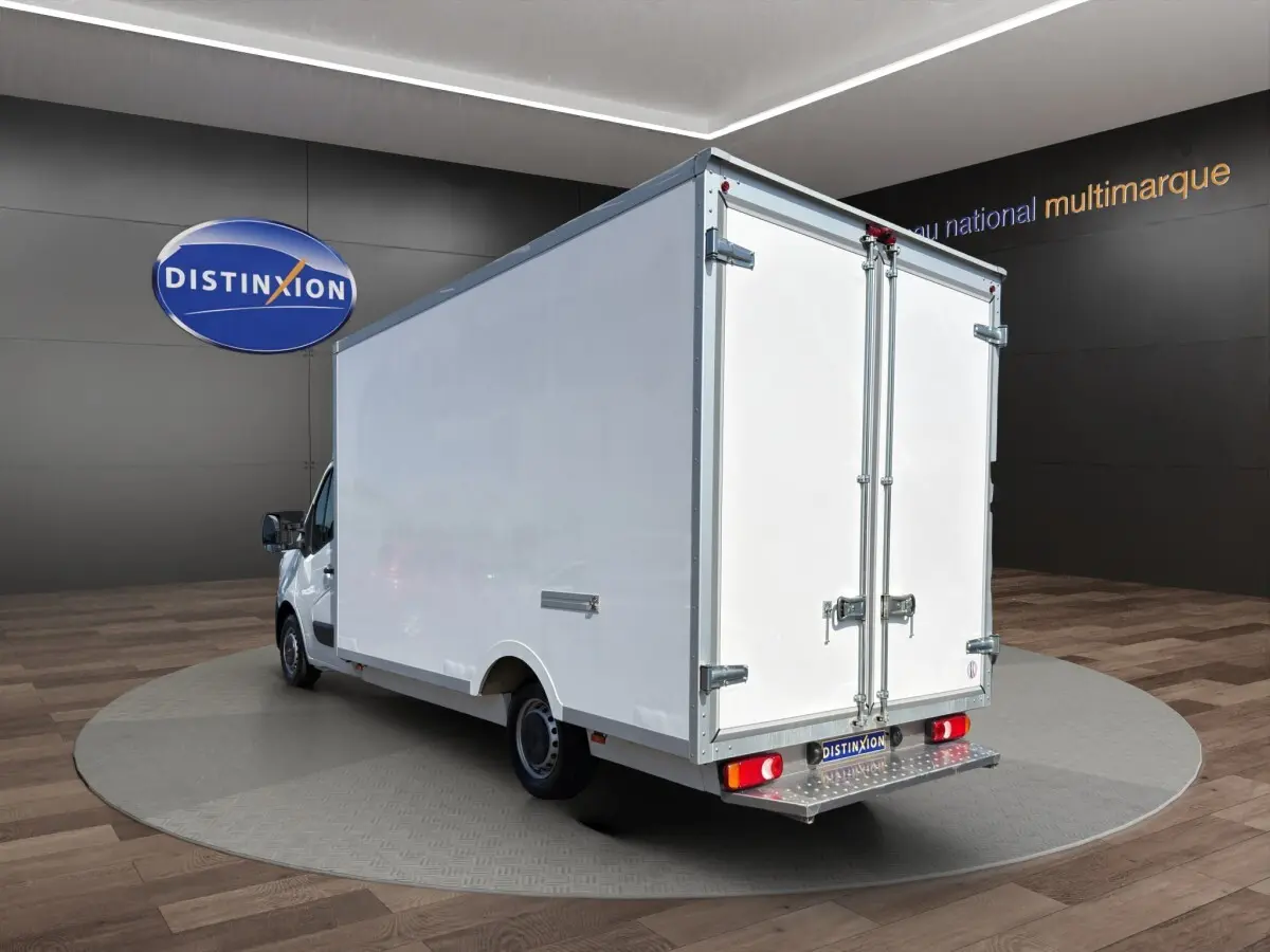 Vue 3/4 arrière d’un Renault Master blanc avec caisse fermée, portes arrière doubles et marchepied métallique.