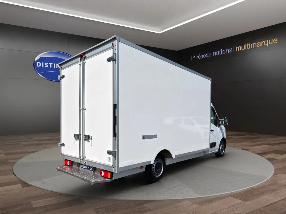 Renault Master blanc vu en 3/4 arrière droit, avec caisse fermée volumineuse et portes arrière battantes.