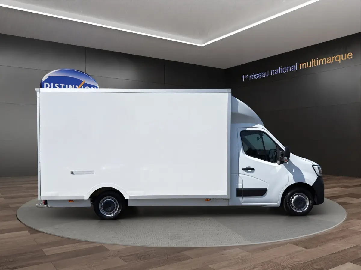 Renault Master blanc en vue profil droit, fourgon utilitaire avec caisse fermée volumineuse, présenté en showroom.