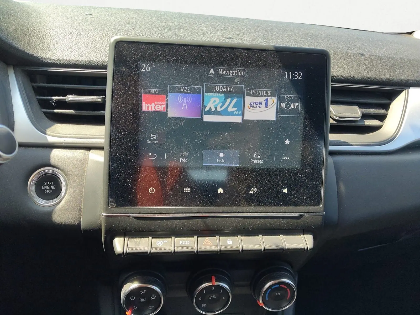 Vue rapprochée du tableau de bord du Renault Captur gris cassiopée 2021, avec écran tactile et commandes climatisation.