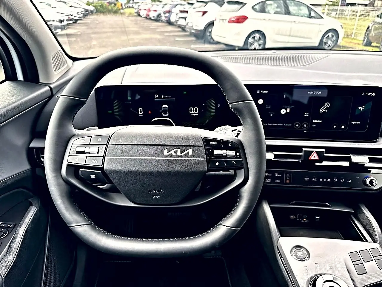 Vue intérieure centrée sur le volant cuir multifonction et le tableau de bord numérique du Kia Sportage blanc 2026.