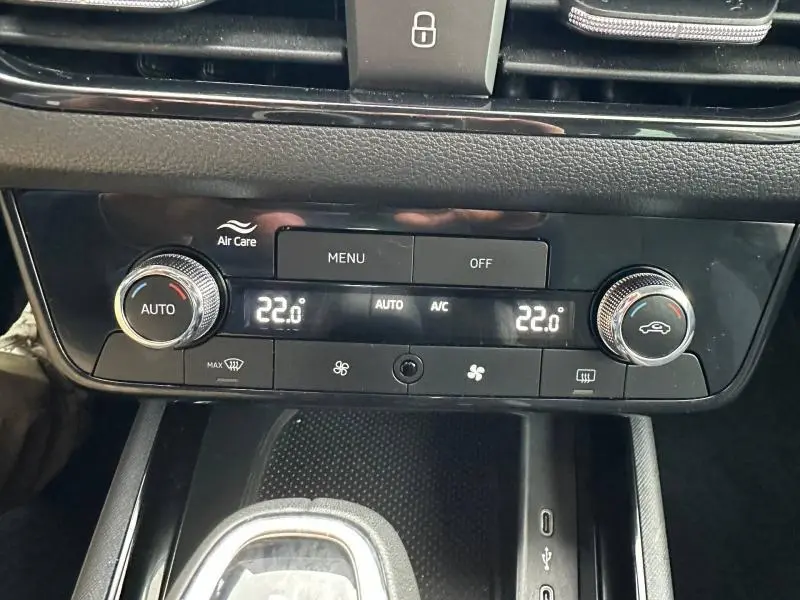 Vue rapprochée de la console centrale noire du Skoda Scala 2025, affichant la climatisation automatique réglée à 22°C.