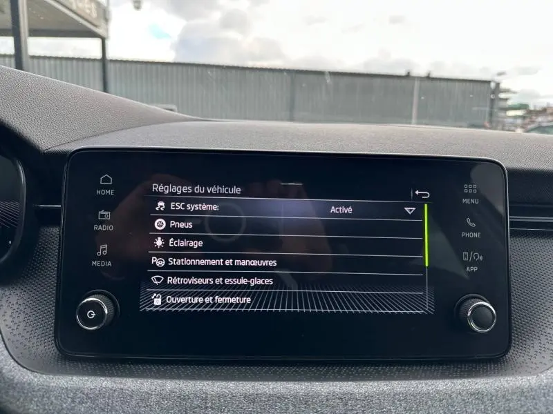Écran tactile central du tableau de bord de la Skoda Scala blanc cristal, affichant les réglages du véhicule.