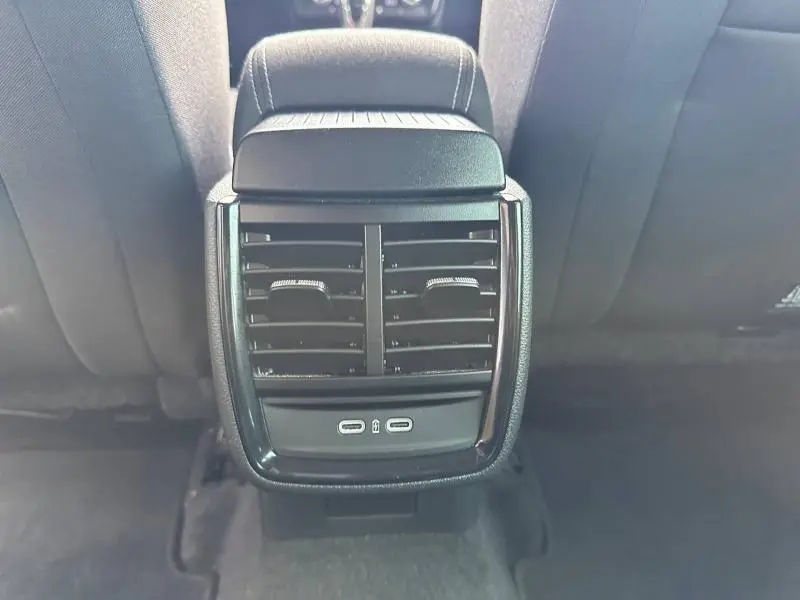 Vue rapprochée de la console arrière noire avec bouches d’aération et ports USB du Skoda Scala blanc cristal.