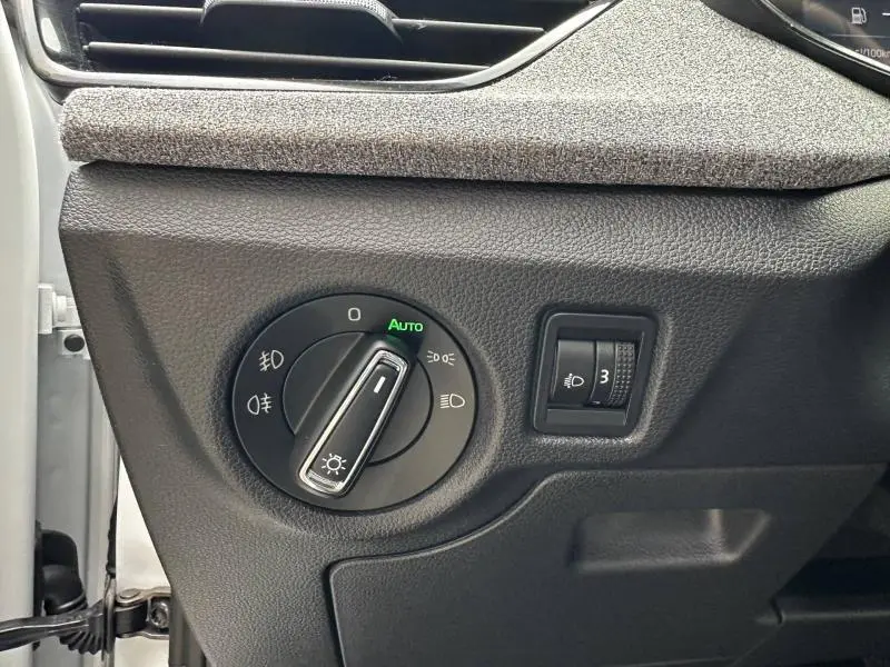 Gros plan sur la commande d’éclairage avec réglage automatique dans l’habitacle d’une Skoda Scala blanc cristal.