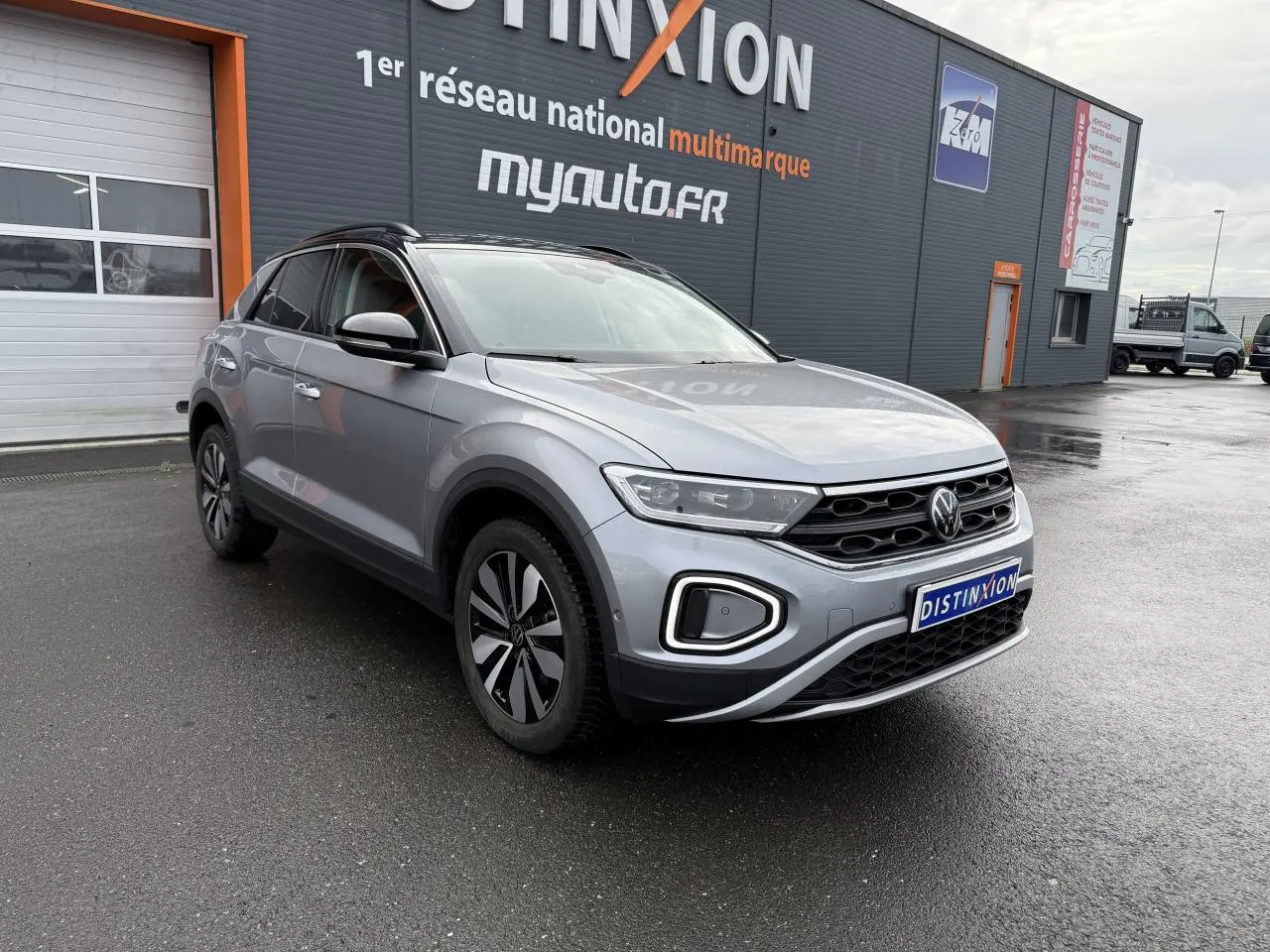 Volkswagen T-Roc 2025 argent pyrite métallisé en 3/4 avant droit, avec jantes alliage 'Zürich' et calandre noire distinctive.