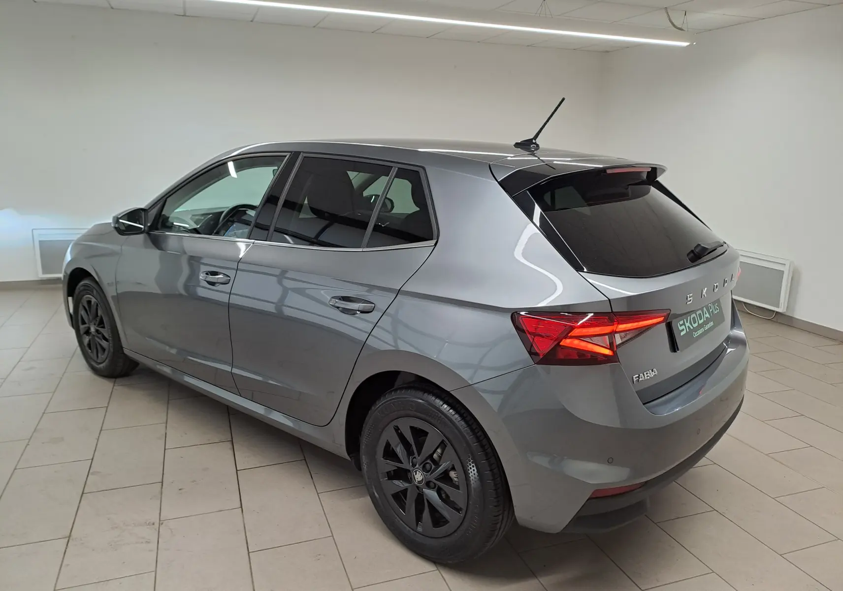 Vue 3/4 arrière droite d'une Skoda Fabia 2025 gris graphite avec vitres surteintées et jantes alliage noires.