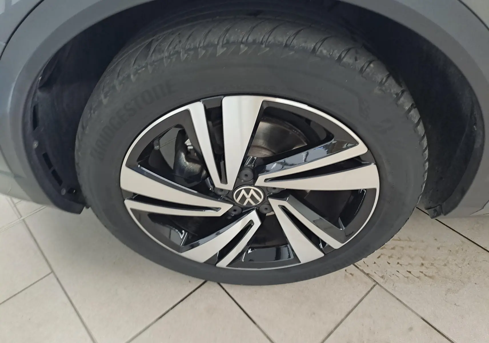Gros plan sur la jante alliage bicolore noire et argentée du Volkswagen T-Roc 1.5 TSI 150 DSG7 R-Line.