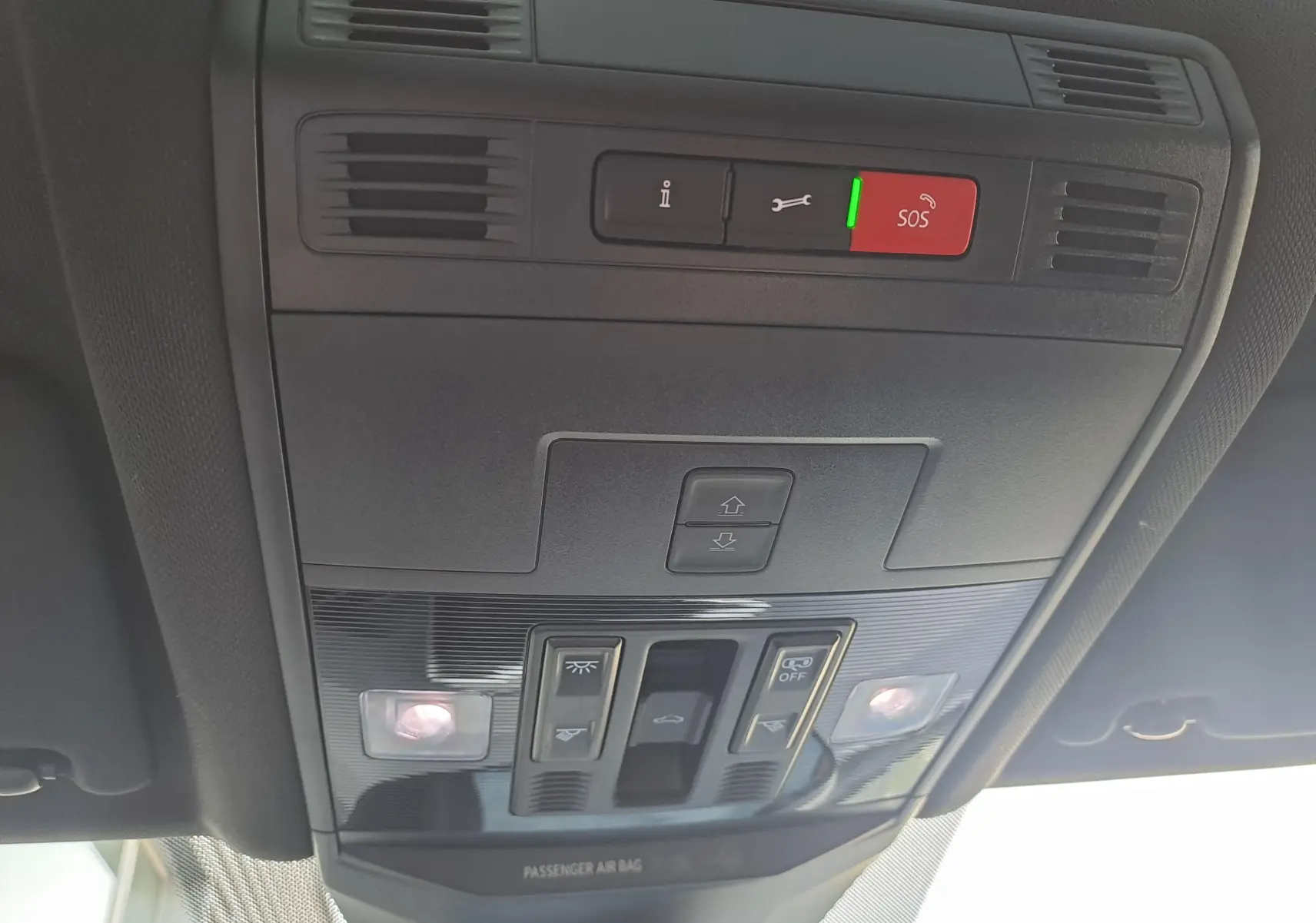 Vue en gros plan du panneau de commandes du toit ouvrant et des éclairages intérieurs du Volkswagen T-Roc 2025 gris Indium avec toit noir.