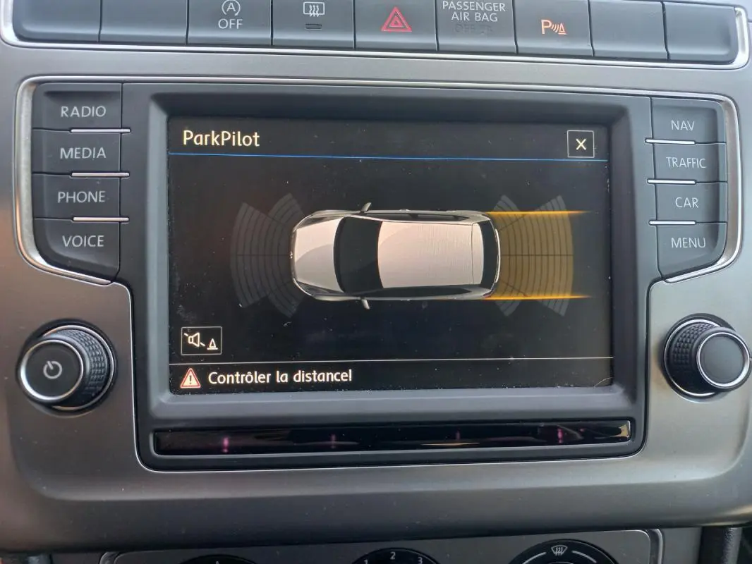 Écran central de la Volkswagen Polo 2016 affichant le système ParkPilot avec vue du véhicule en gris et alertes de distance.