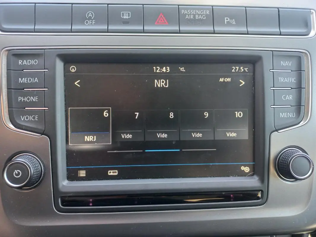 Tableau de bord de Volkswagen Polo gris 2016, vue rapprochée de l'écran multimédia affichant la radio NRJ.