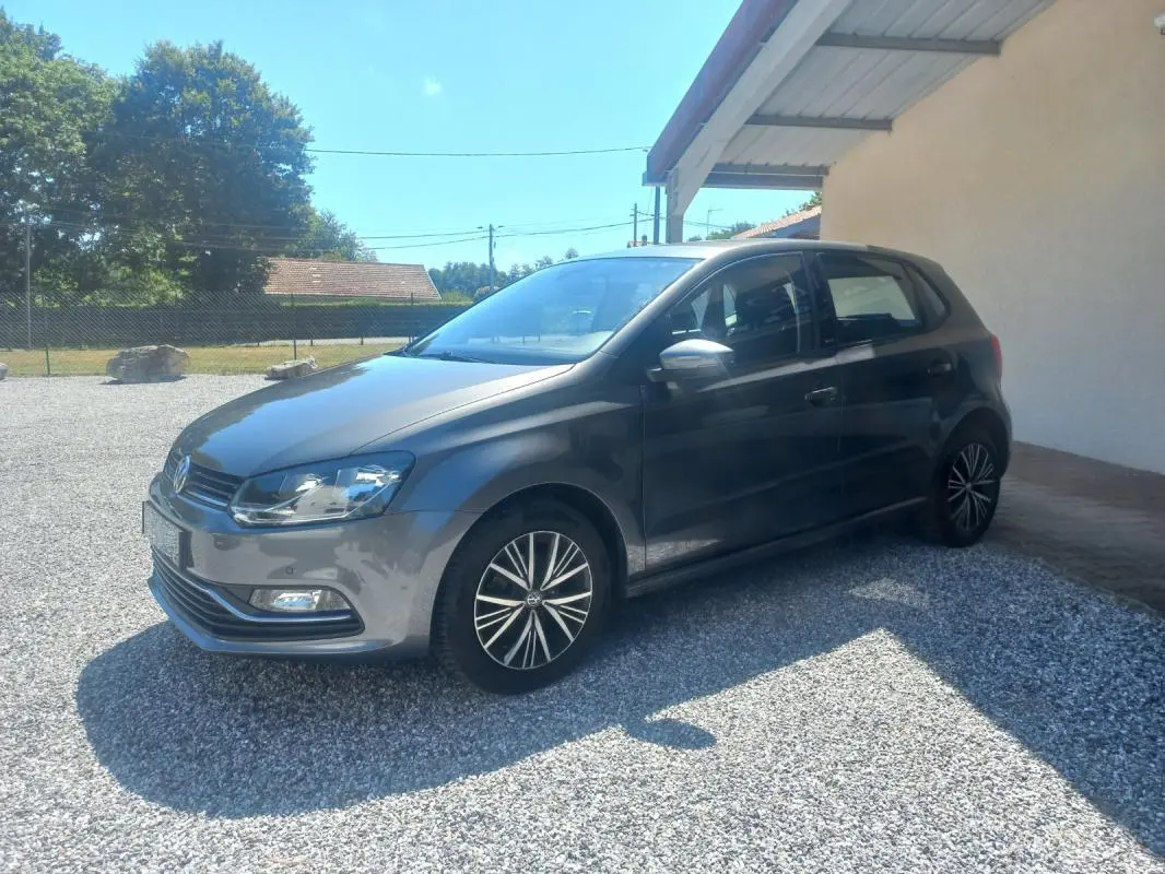 Volkswagen Polo gris 2016 vue 3/4 avant côté gauche, avec jantes alliage et rétroviseurs argentés.