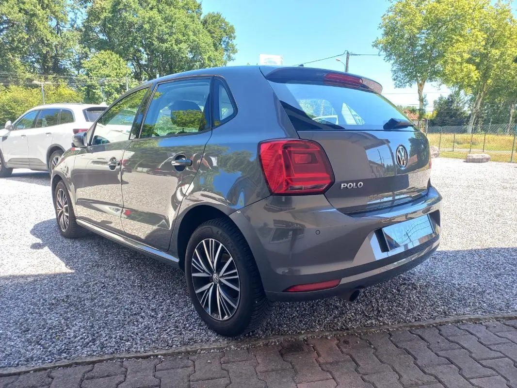 Vue 3/4 arrière droite d'une Volkswagen Polo gris métallisé 2016 avec jantes alliage et feux arrière distinctifs.