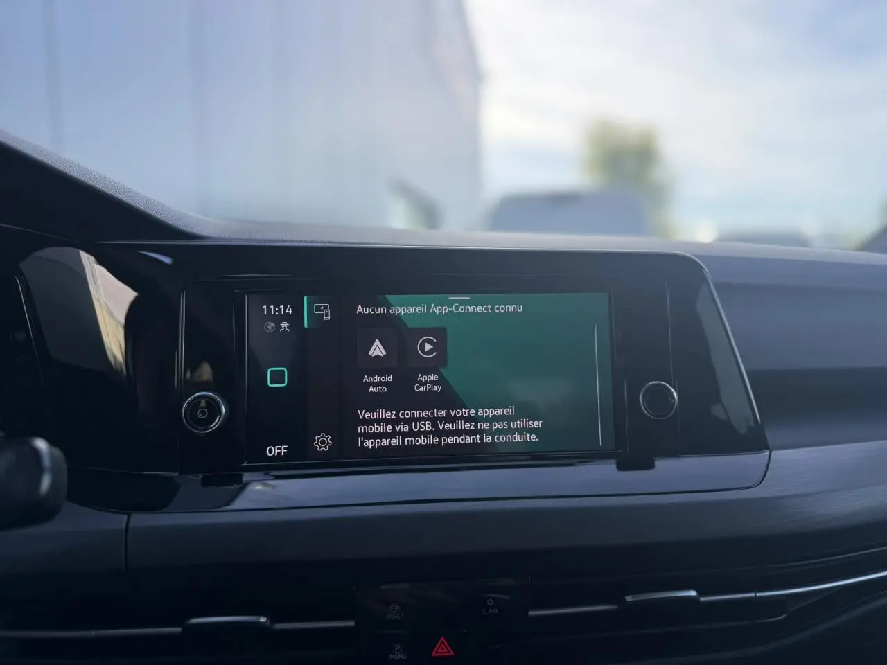 Vue rapprochée de l'écran tactile central du tableau de bord de la Volkswagen Golf VIII noire, affichant l'interface App-Connect.