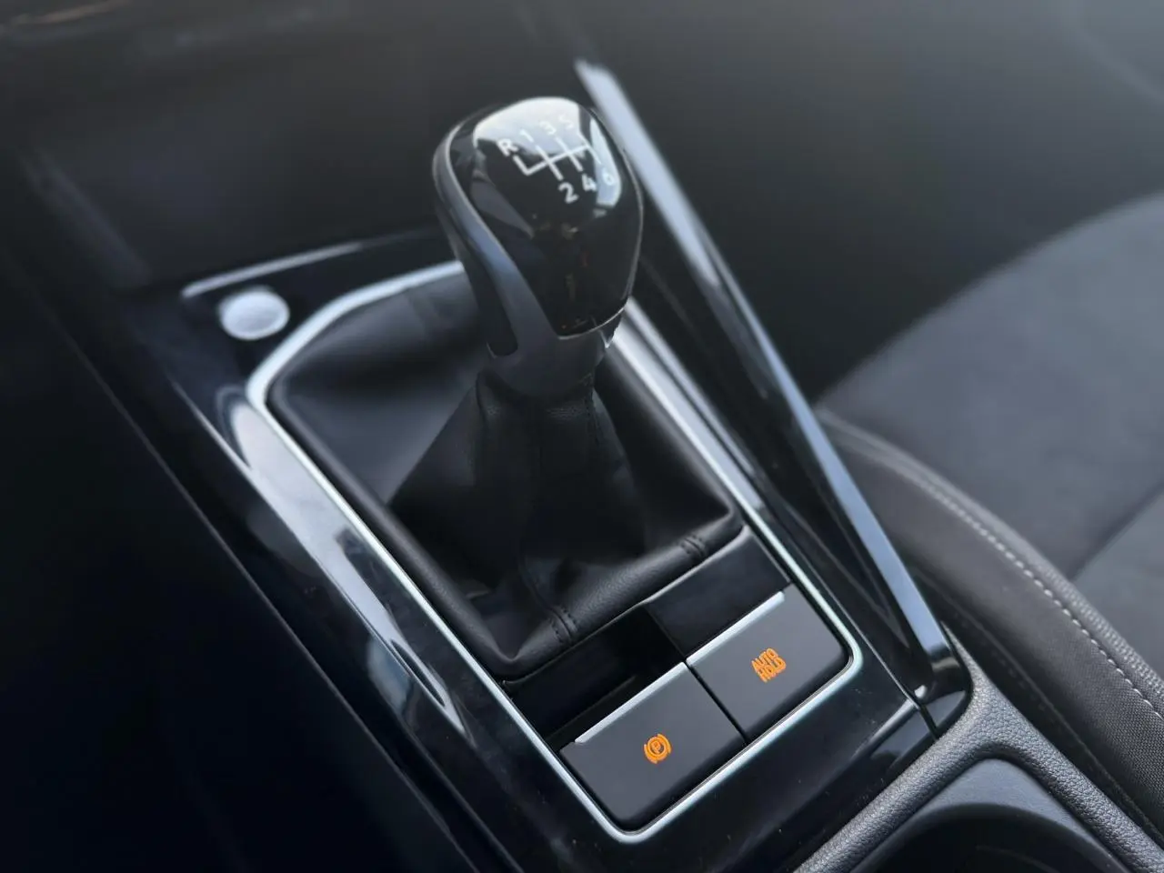 Gros plan sur le levier de vitesses manuel noir et la console centrale brillante de la Volkswagen Golf VIII 1.5 TSI.