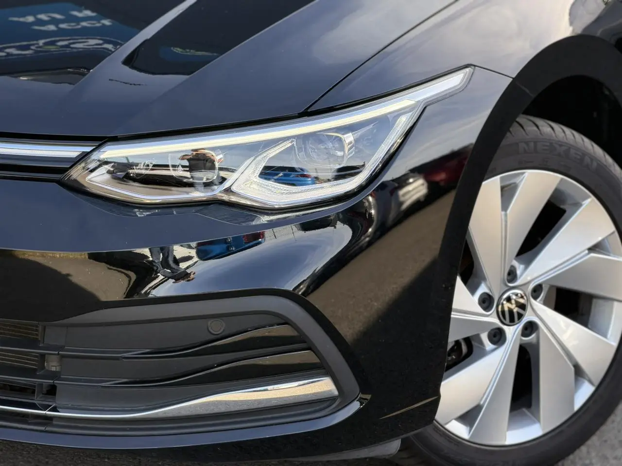 Gros plan sur l'avant droit noir nacré d'une Volkswagen Golf VIII 2024, avec phare LED et jante alliage 17 pouces.