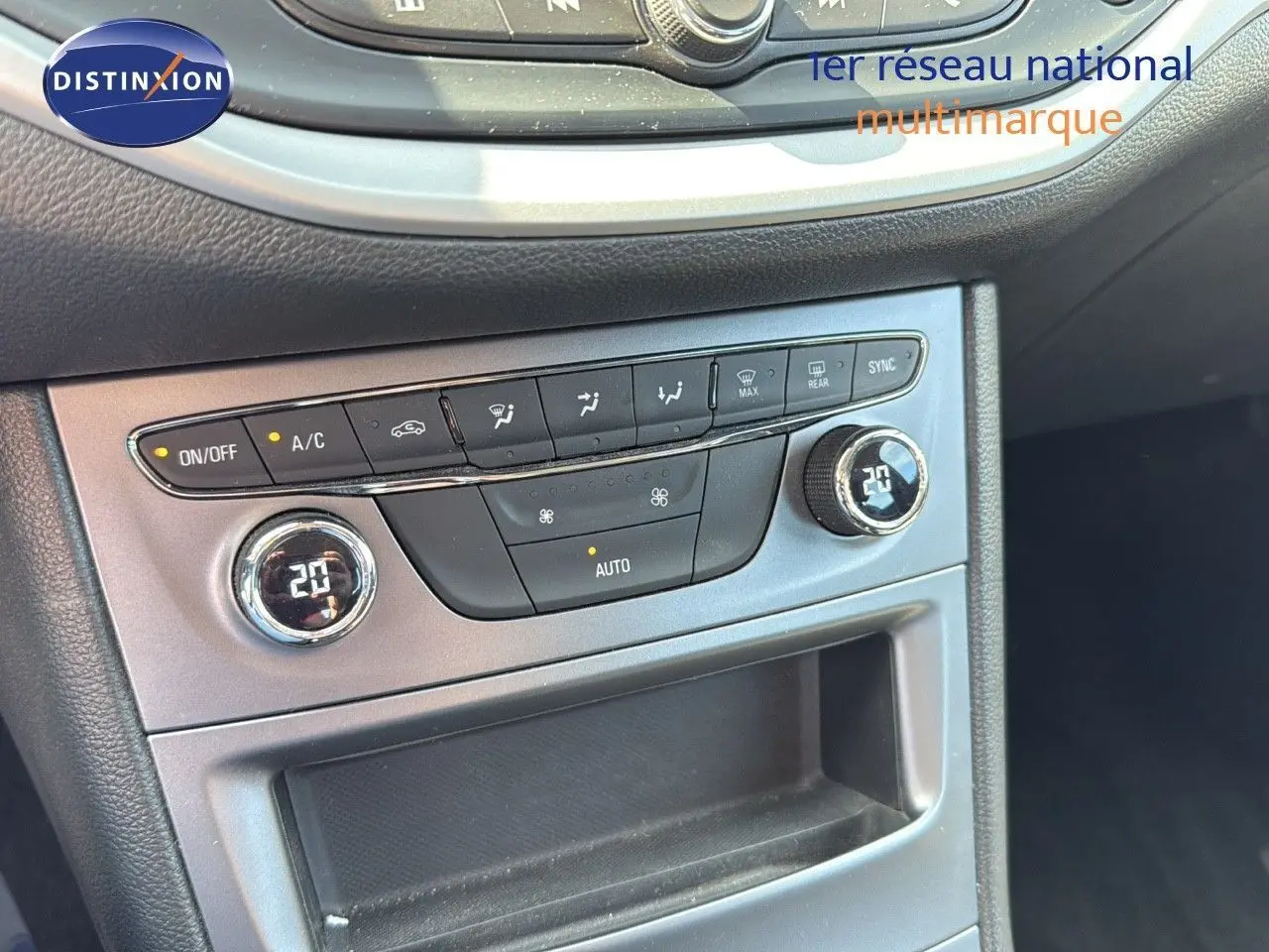 Panneau de commande de climatisation automatique de l’Opel Astra Sports Tourer gris minéral, affichant 20°C côté conducteur et passager.