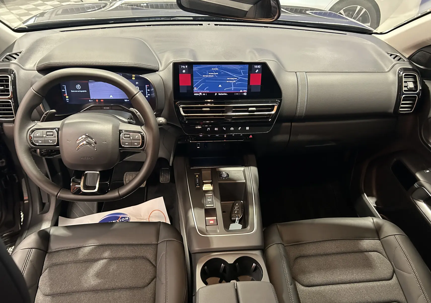 Vue intérieure avant du Citroën C5 Aircross 2025 gris platinium, avec tableau de bord numérique et écran GPS central tactile.
