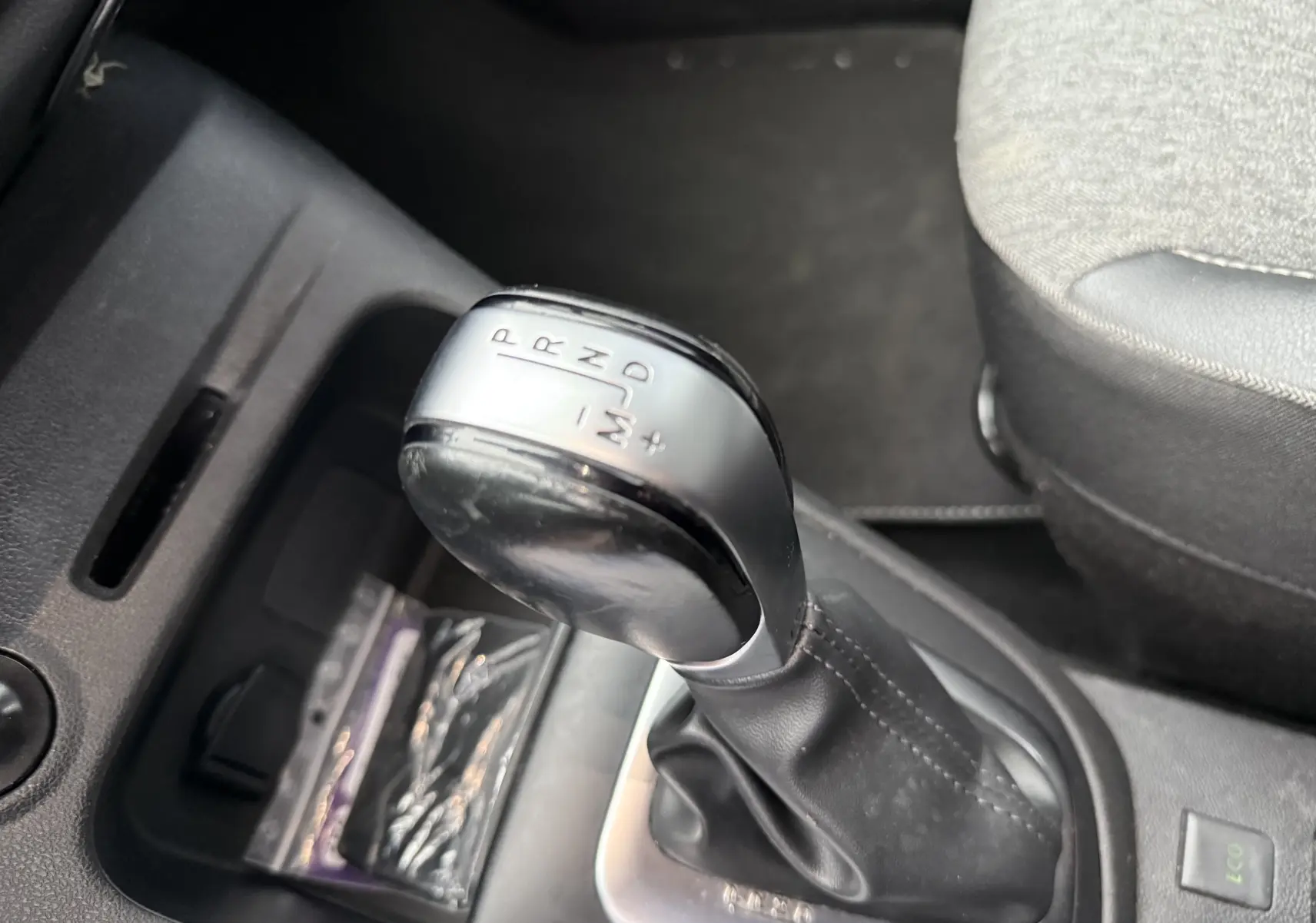 Gros plan sur le levier de vitesses automatique noir et argenté dans l’habitacle du Renault Captur rouge de 2017.