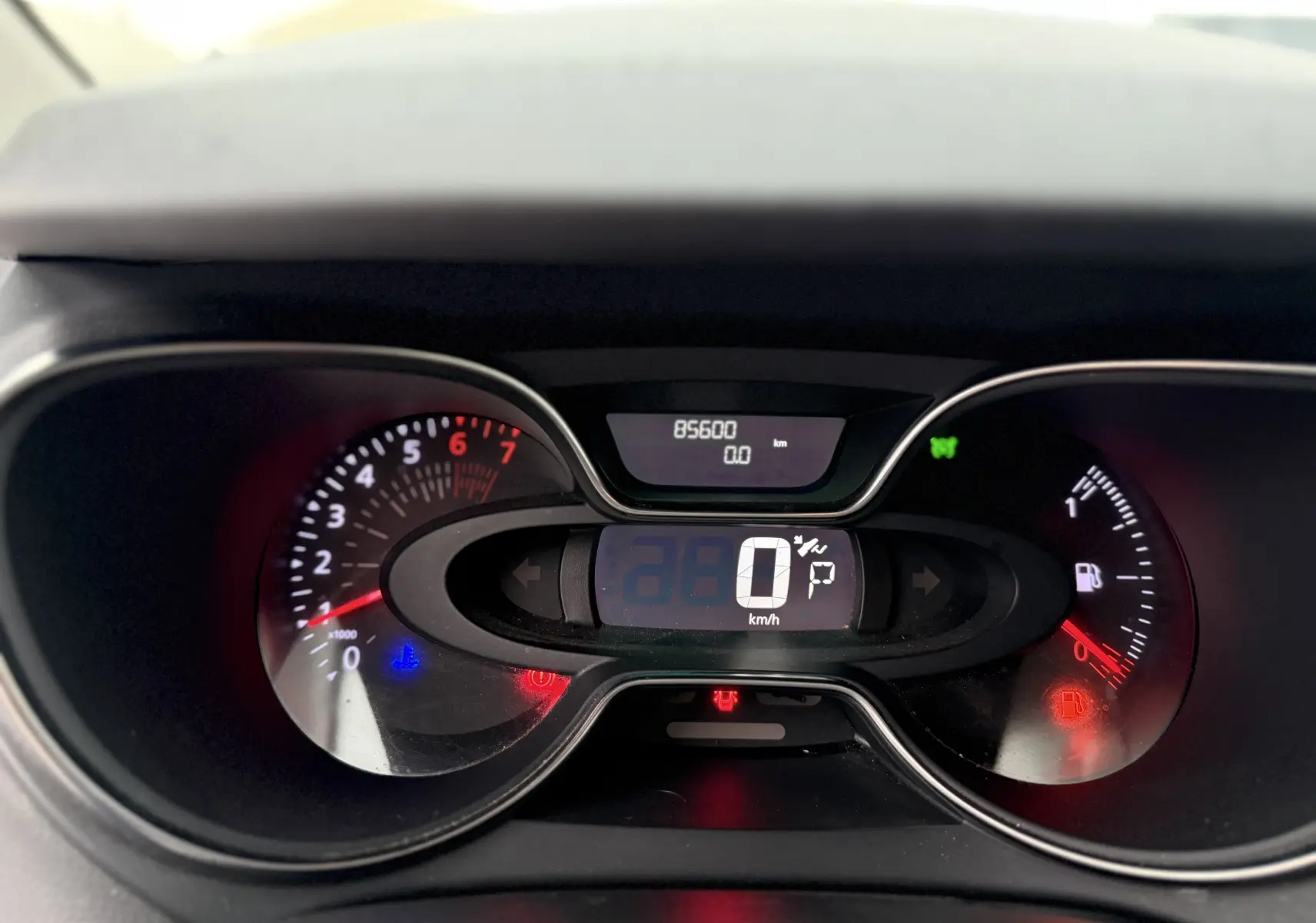 Vue rapprochée du tableau de bord numérique du Renault Captur rouge 2017, affichant 85 600 km et vitesse à 0 km/h.