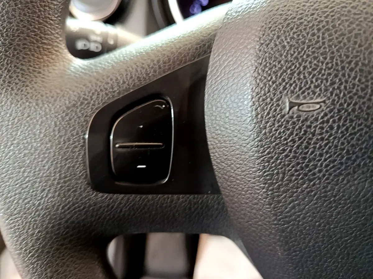 Gros plan sur le volant noir du Renault Trafic Fourgon L1H1 1200 Confort 2021 avec commande intégrée et bouton klaxon visible.