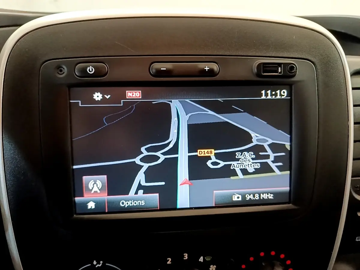 Écran GPS central du Renault Trafic Fourgon blanc, vue rapprochée du tableau de bord avec navigation affichée.