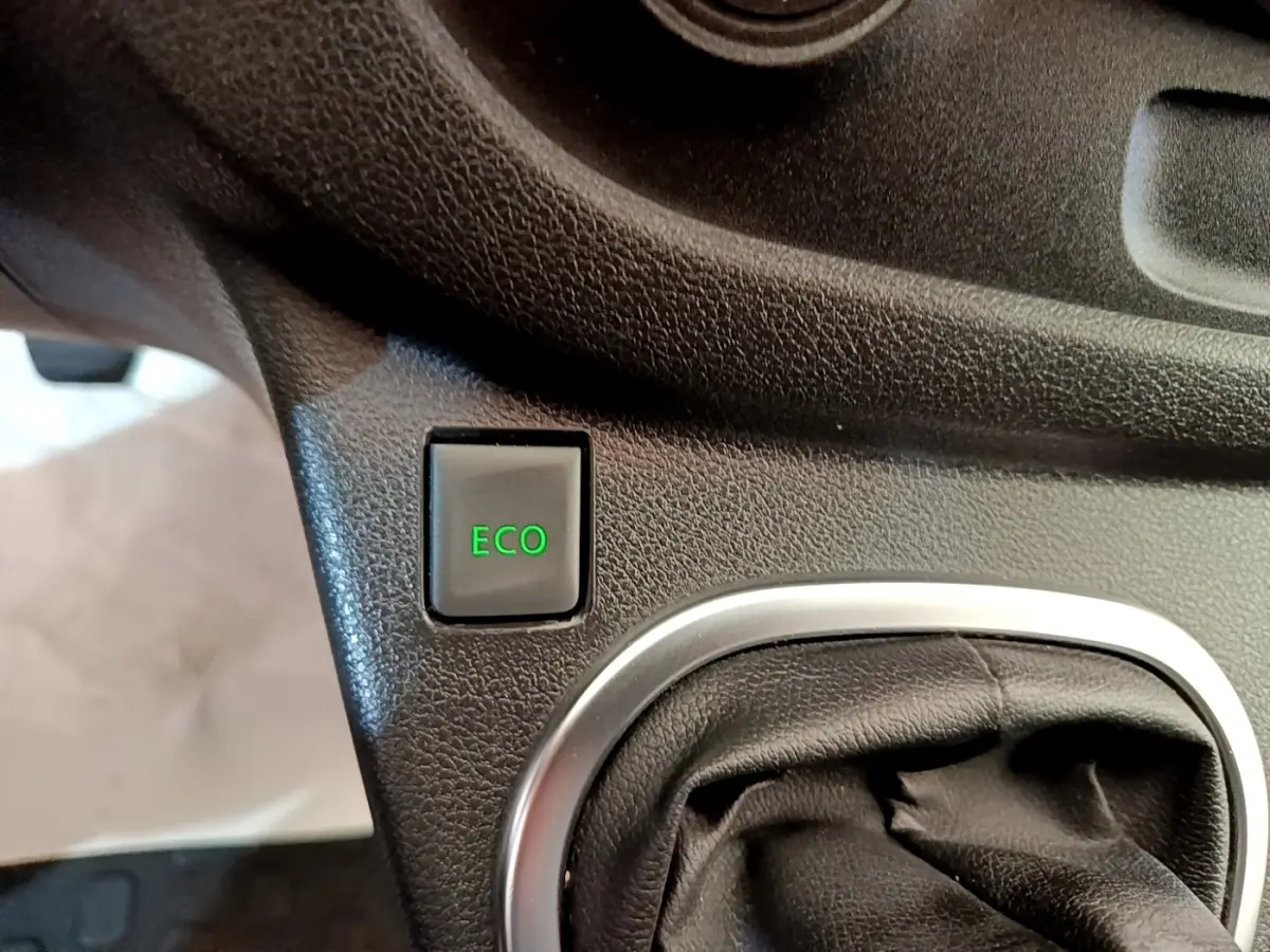 Gros plan sur le bouton ECO vert et le soufflet de levier de vitesse noir dans l’habitacle du Renault Trafic blanc.