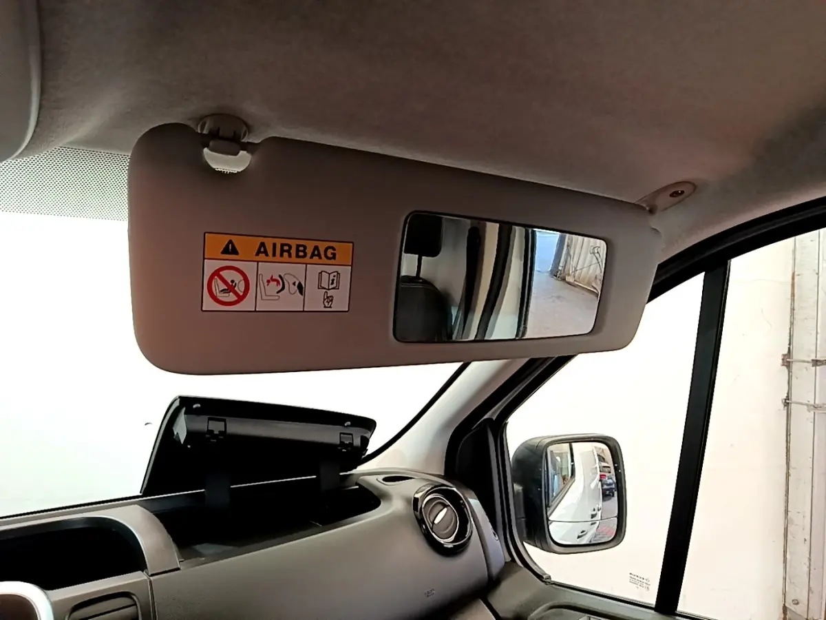 Vue intérieure côté passager du Renault Trafic Fourgon blanc 2021, avec pare-soleil et rétroviseur extérieur visible.