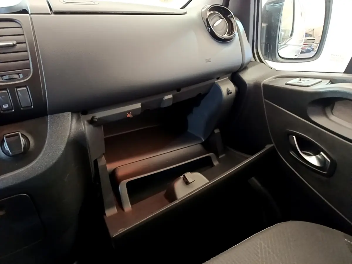 Intérieur noir du Renault Trafic Fourgon L1H1 1200 Confort 2021, vue sur la boîte à gants ouverte côté passager.