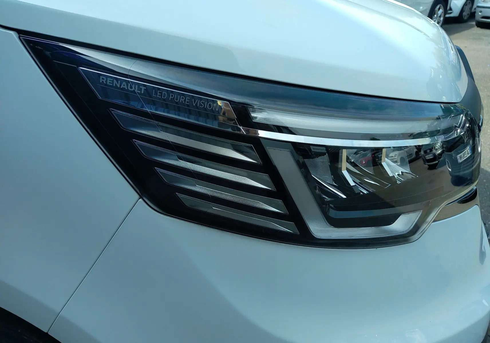 Gros plan sur le phare avant gauche blanc du Renault Trafic Fourgon 2024 avec éclairage LED Pure Vision.