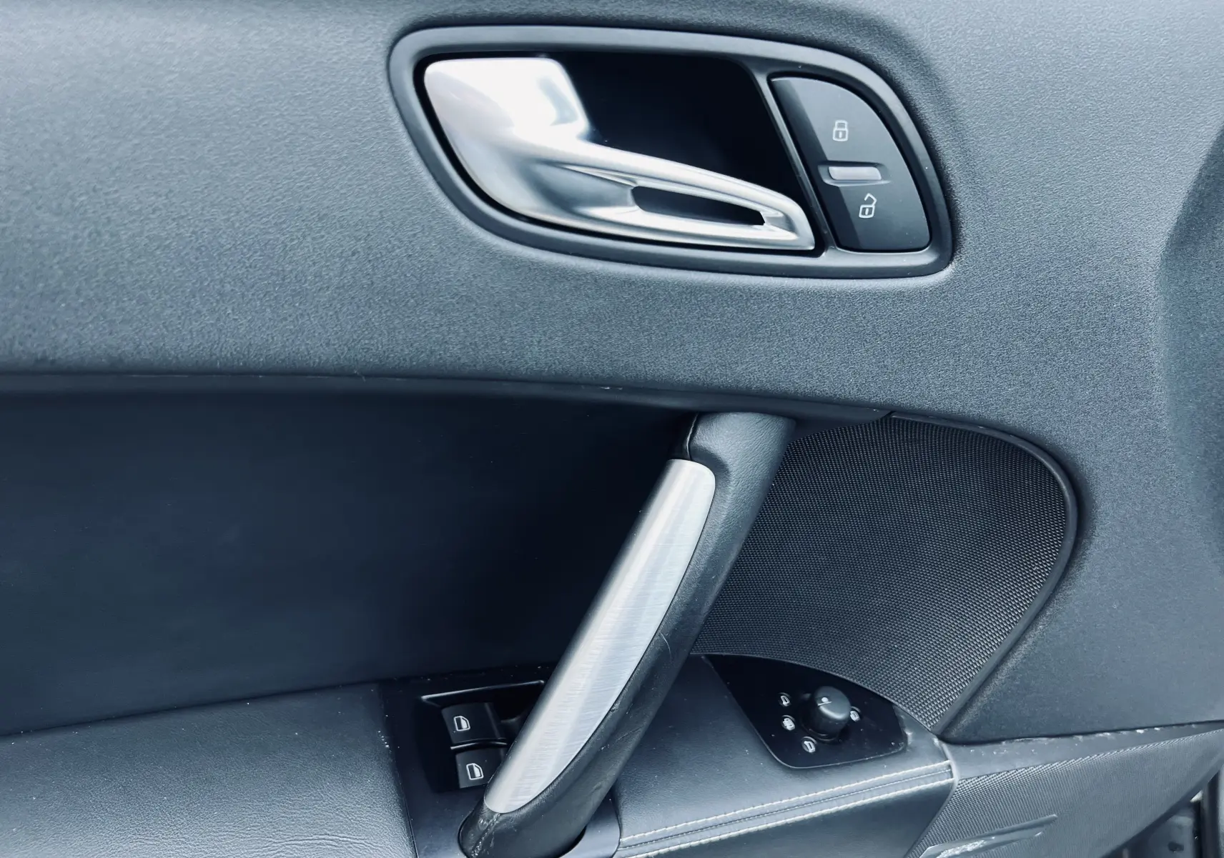 Poignée de porte intérieure côté conducteur de l'Audi TT RS Roadster 2009 avec commandes de verrouillage et haut-parleur Bose.