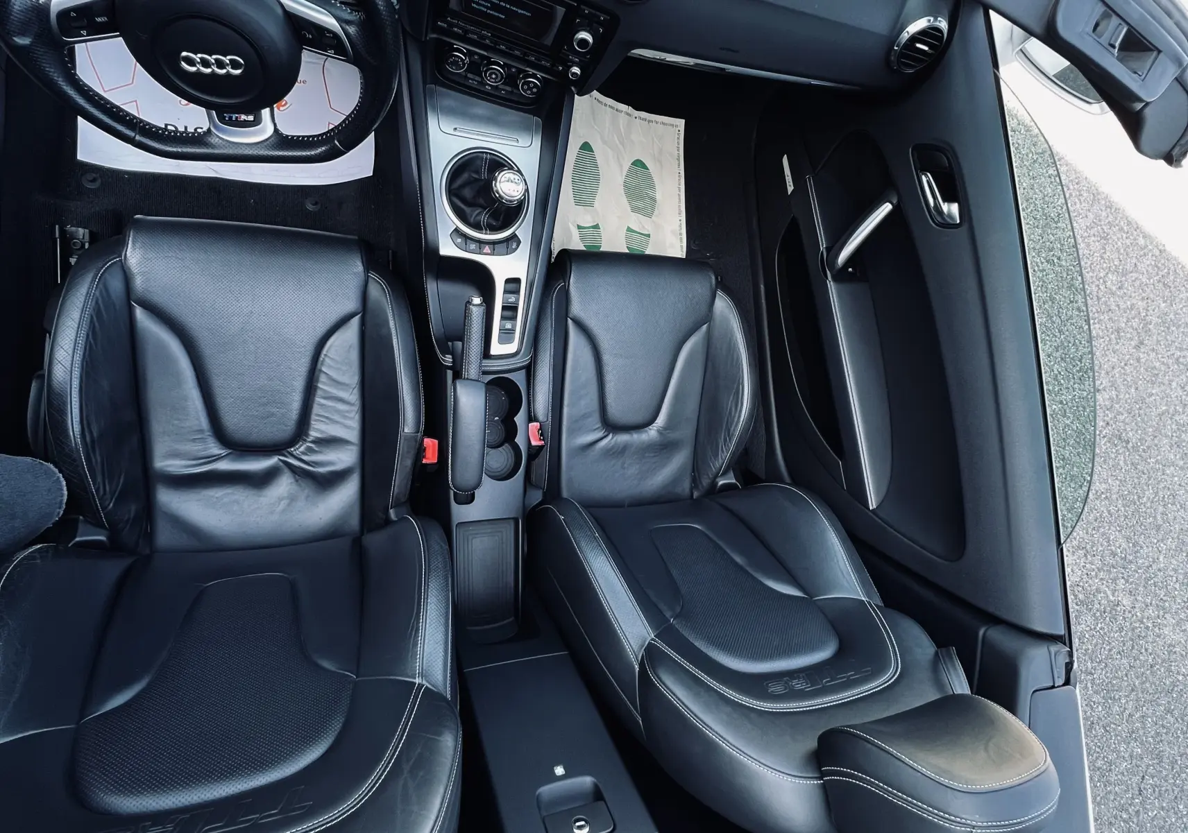 Vue intérieure de l'Audi TT RS Roadster 2009 cabriolet, sièges baquet cuir noir et tableau de bord avec boîte manuelle.