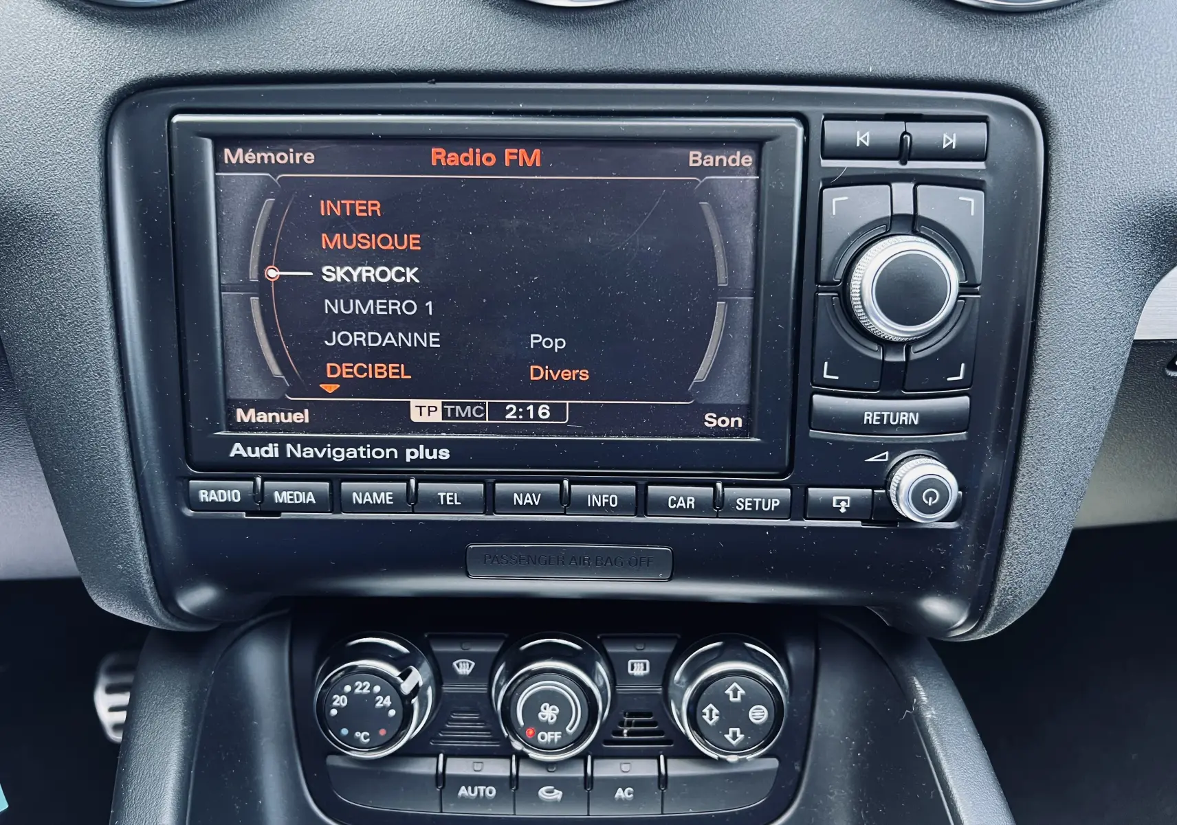 Gros plan sur la console centrale noire de l'Audi TT RS Roadster 2009 avec écran de navigation et commandes climatisation.