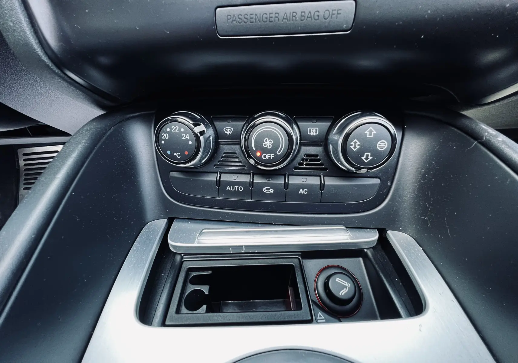 Vue rapprochée du tableau de bord de l'Audi TT RS Roadster 2009 montrant les commandes de climatisation et l'allume-cigare.