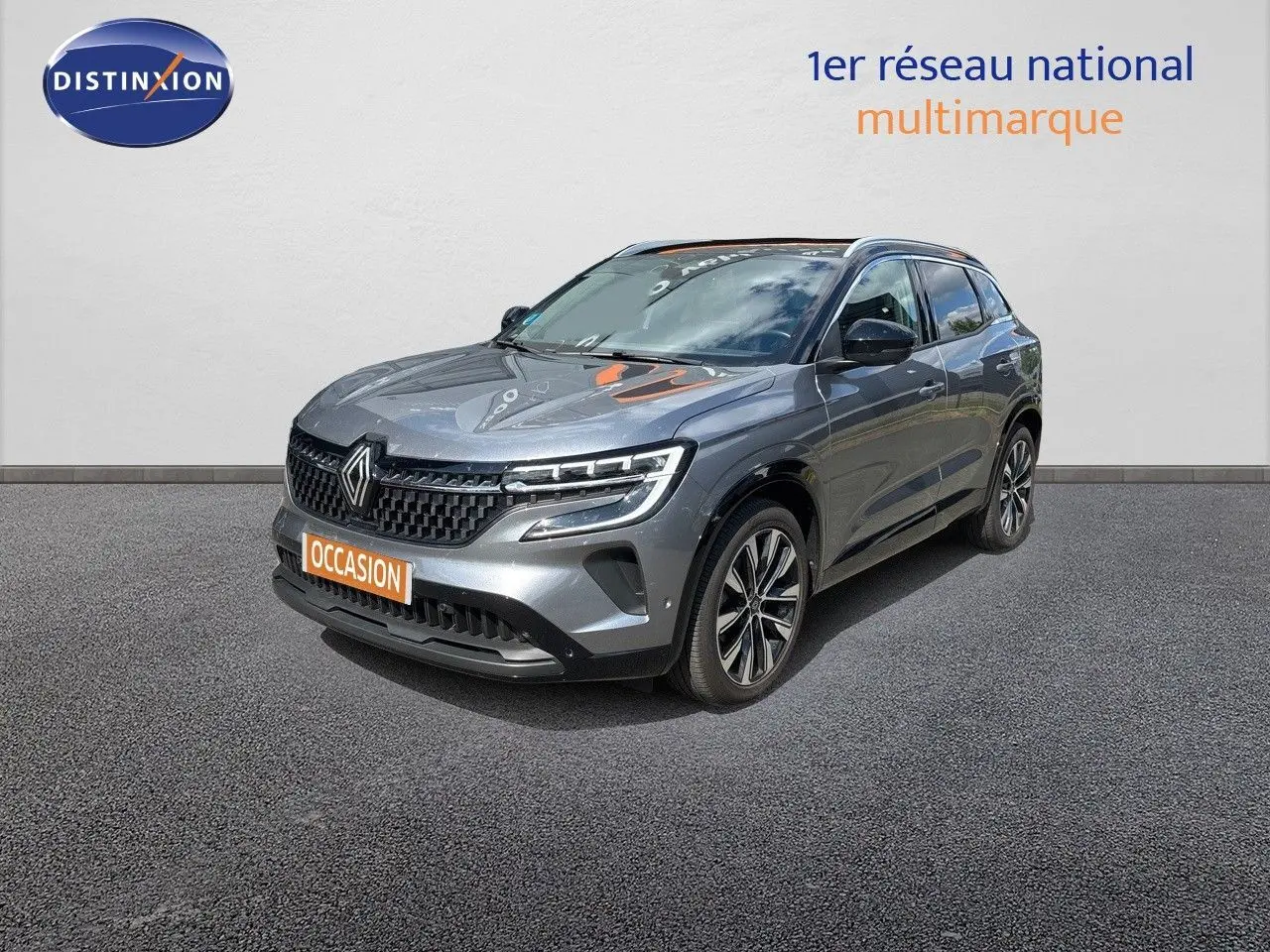 Renault Austral gris schiste métal en 3/4 avant droit, mettant en valeur ses phares LED et sa calandre distinctive.