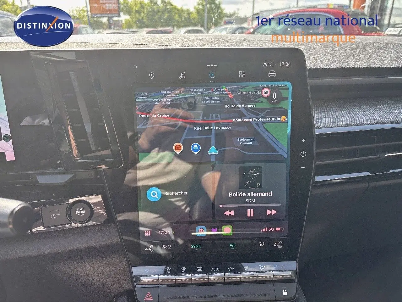 Vue rapprochée de l'écran tactile central du tableau de bord du Renault Austral gris schiste, affichant la navigation et la musique.