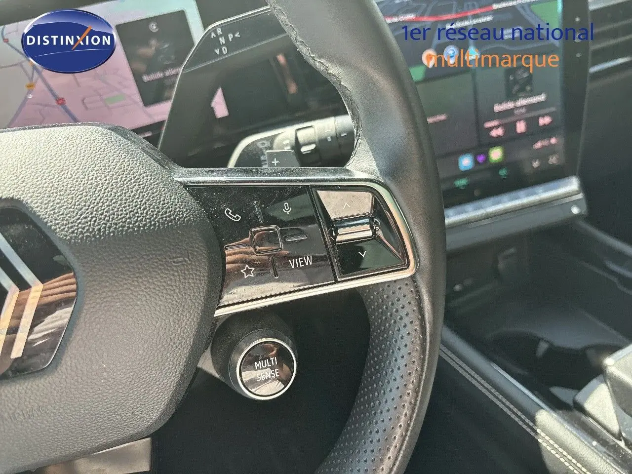 Gros plan sur le volant noir perforé du Renault Austral 2024 avec commandes intégrées et bouton Multi Sense visible.