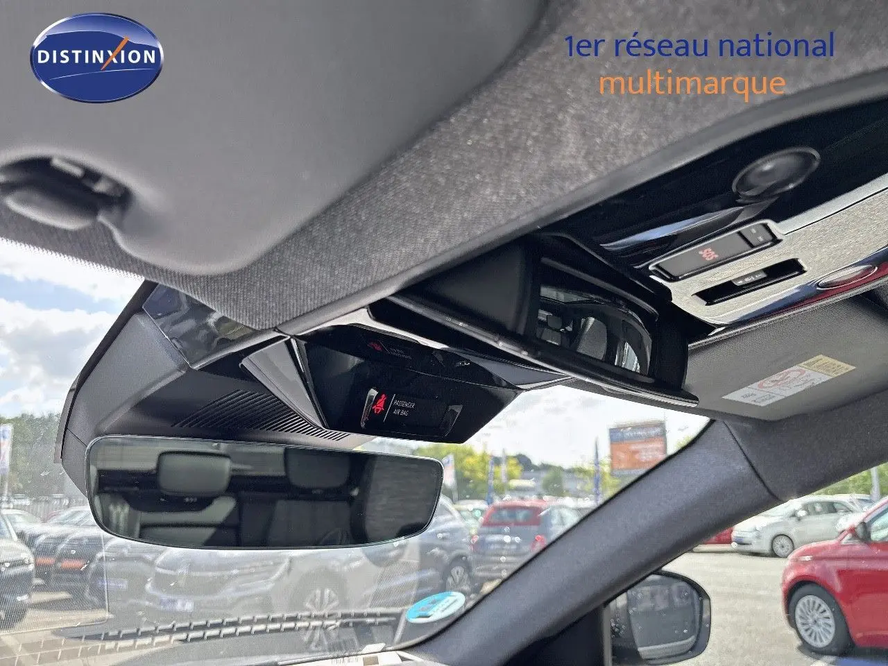 Vue intérieure du rétroviseur central et du plafonnier d'un Renault Austral gris schiste métal, avec commandes et affichage airbag.