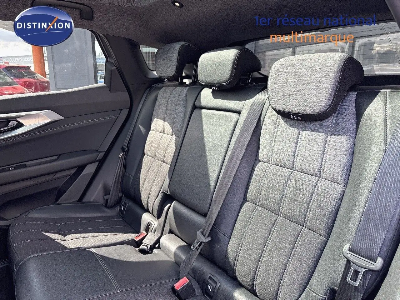 Vue intérieure arrière des sièges du Renault Austral 2024, tissu gris clair et cuir noir, avec appuie-têtes et ceintures visibles.