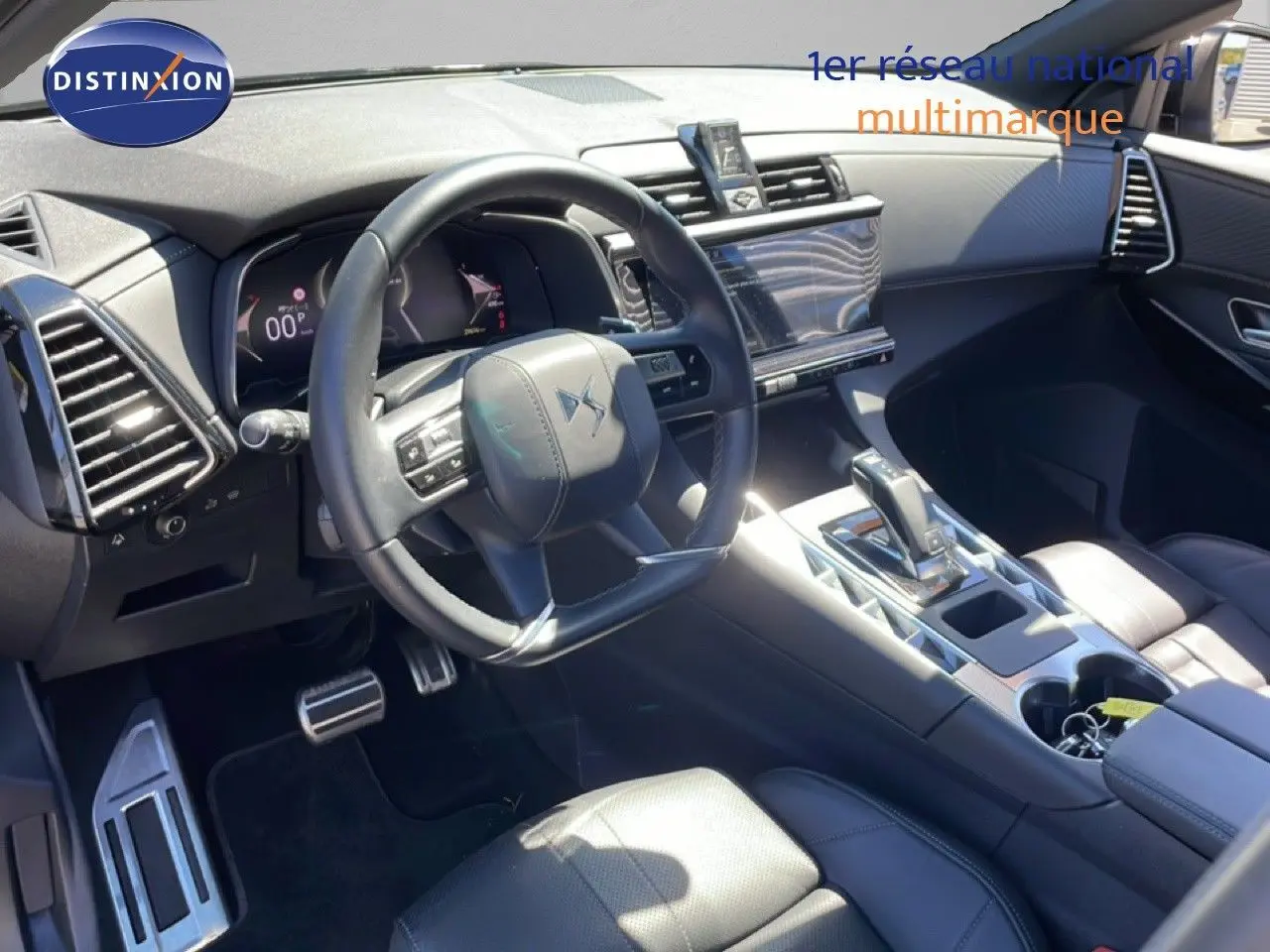 Vue intérieure de face du poste de conduite du DS7 2024 noir métal, avec volant cuir et console centrale moderne.