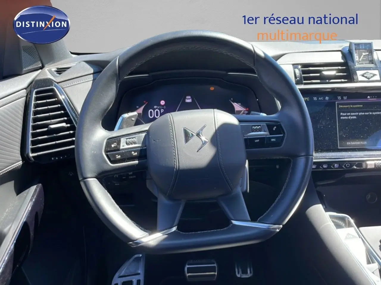 Vue rapprochée du volant cuir noir du DS7 2024 avec commandes intégrées et tableau de bord numérique lumineux.