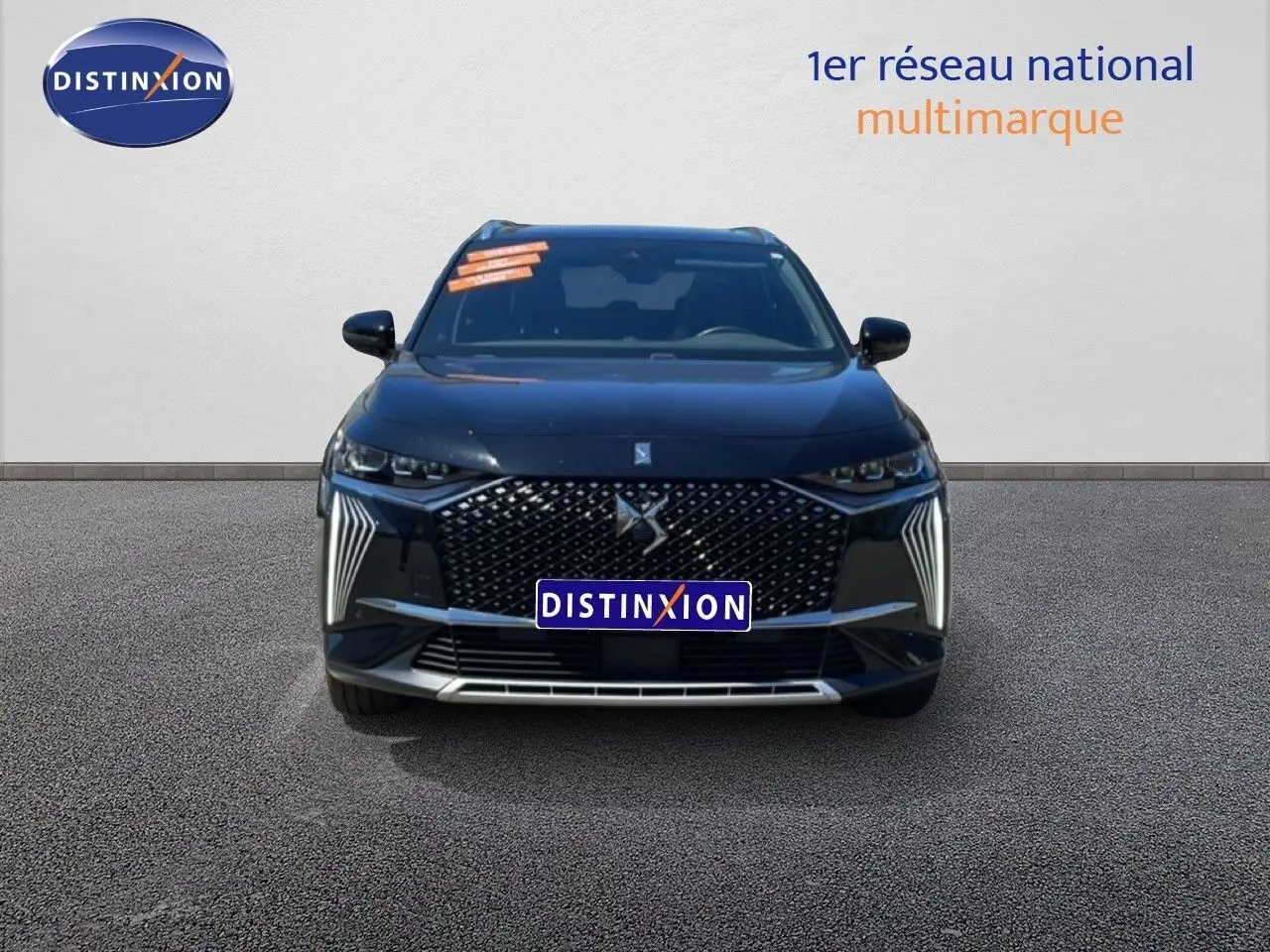 Vue frontale d'un DS7 Noir Métal 2024 avec calandre distinctive et feux LED verticaux allumés.