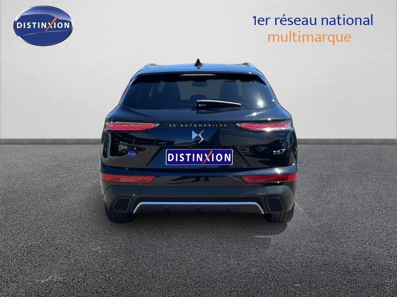 Vue arrière d'un DS7 noir métal 2024 avec feux LED étirés et logo DS centré sur un fond neutre.
