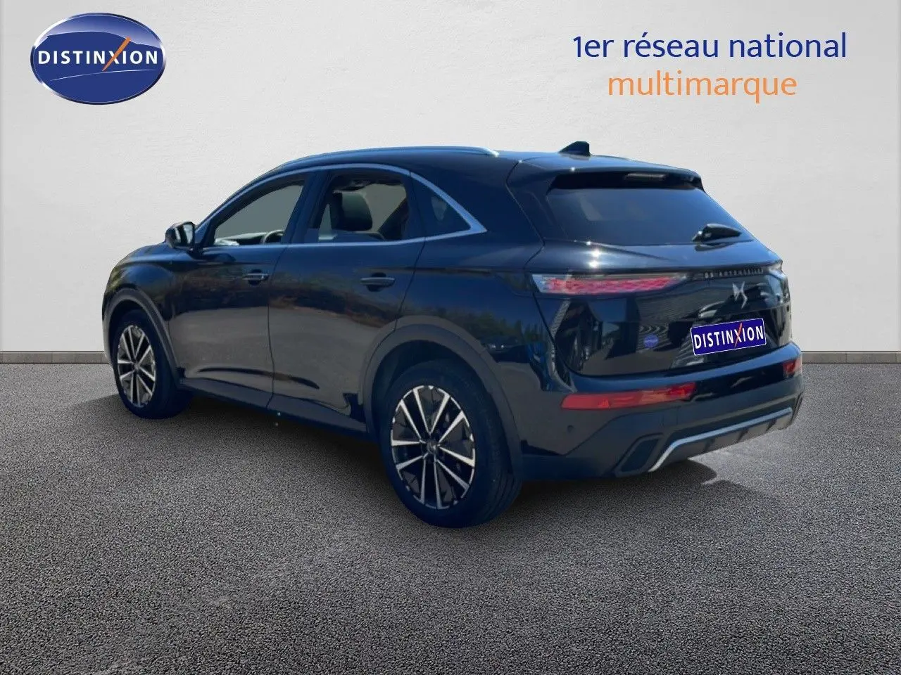 Vue 3/4 arrière droite d'un DS7 2024 noir métal avec jantes bi-ton et feux arrière LED distinctifs.