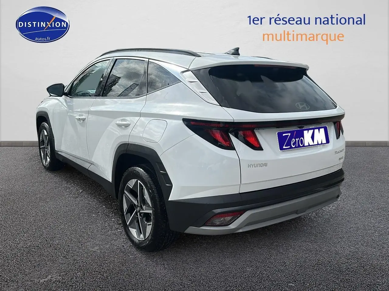 Vue 3/4 arrière droite d'un Hyundai Tucson blanc sérénité avec jantes alliage et vitres teintées.