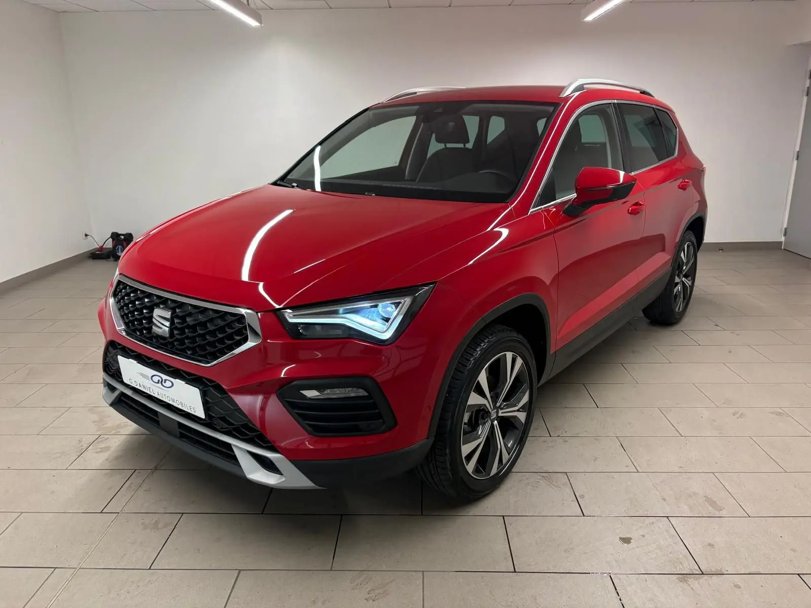 SEAT Ateca Rouge Velvet en 3/4 avant droit, mettant en valeur sa calandre et ses feux LED distinctifs.