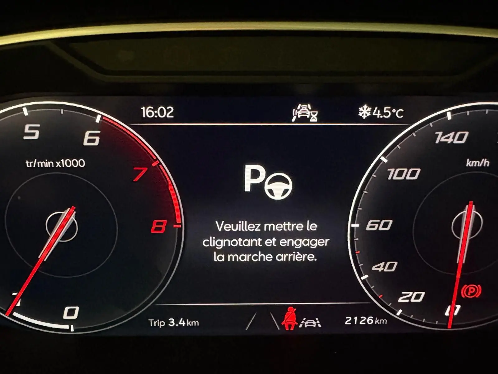 Tableau de bord numérique du SEAT Ateca 2024 affichant un message d'alerte au stationnement, avec compte-tours et compteur de vitesse.
