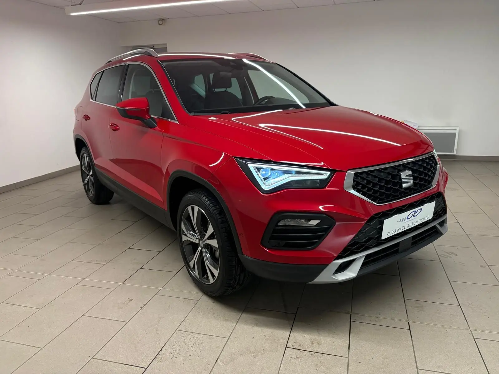 SEAT Ateca Rouge Velvet en 3/4 avant droit, mettant en valeur sa calandre noire et ses jantes alliage distinctives.